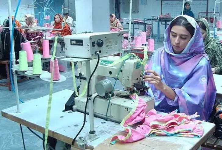 Textile workers sewing in garment factory